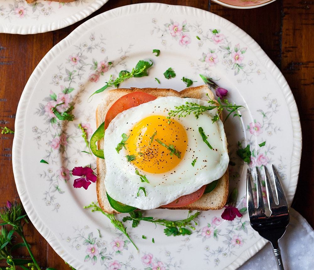 Fried egg on toast with smoked salmon and greens