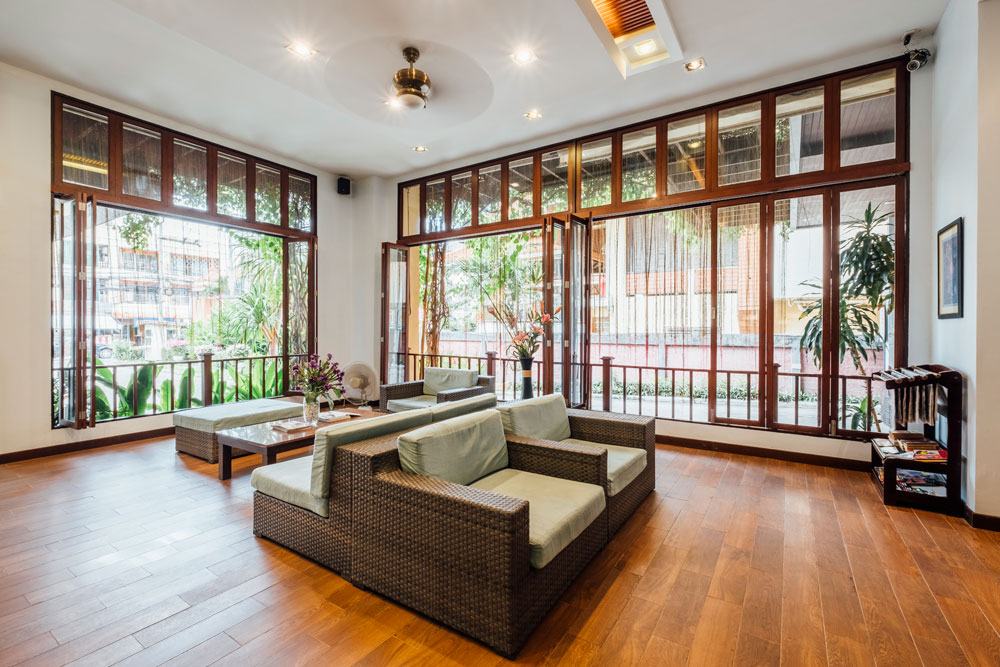 The sunroom with armchairs and garden windows